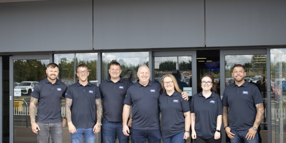Seven members of the Azul team in branded shirts outside Teesside International Airport